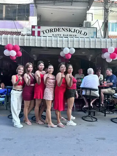 The team in red outside the bar under the Tordenskjold sign, decorated with red and white balloons
